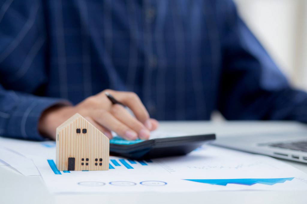 Hand of business man agent calculating loan of finance and investment for real estate.